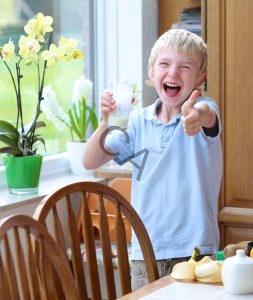 Boy enjoying a glass of colostrum milk